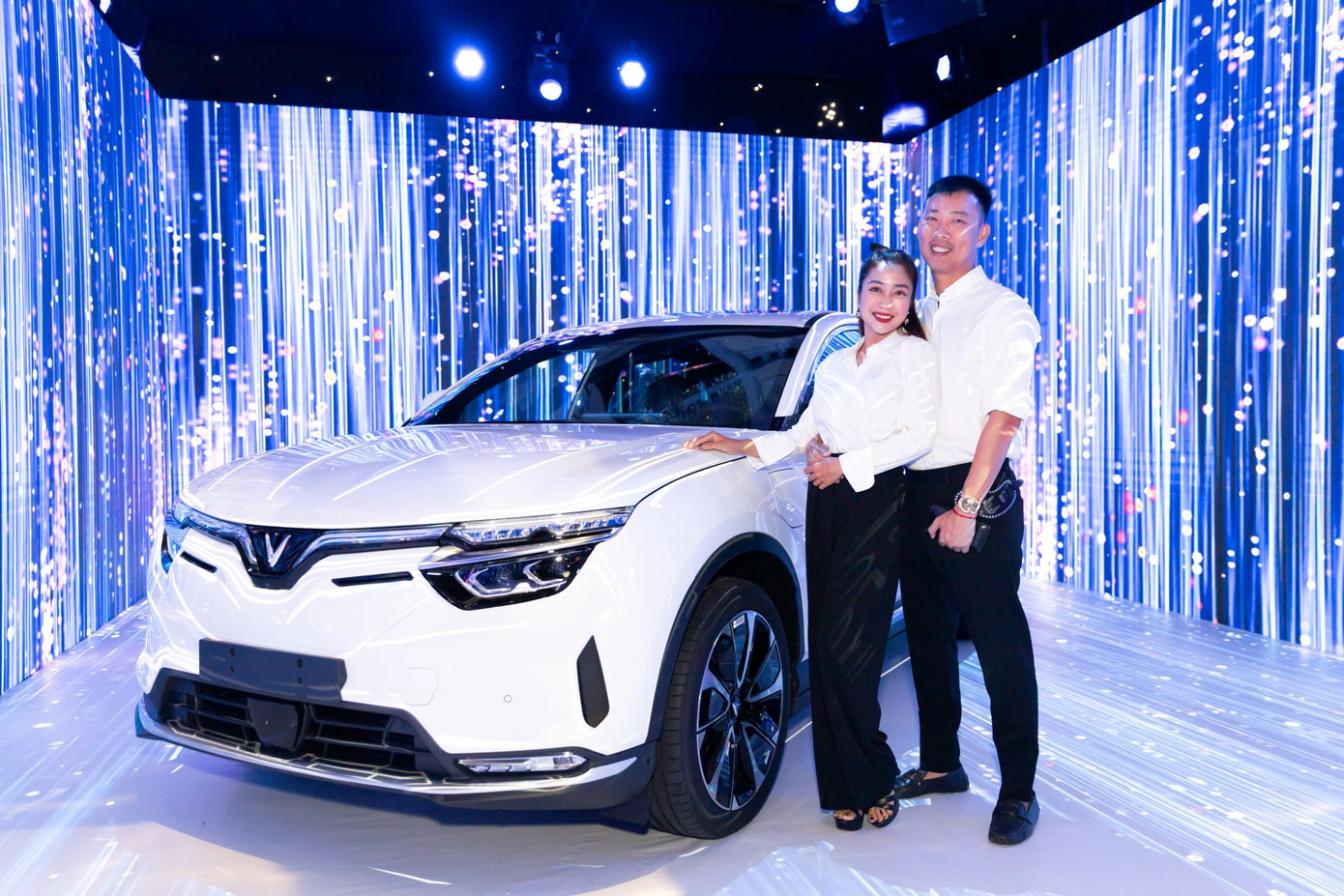 Vợ chồng diễn viên Ốc Thanh Vân check-in bên chiếc VF 8 trong khuôn viên triển lãm.