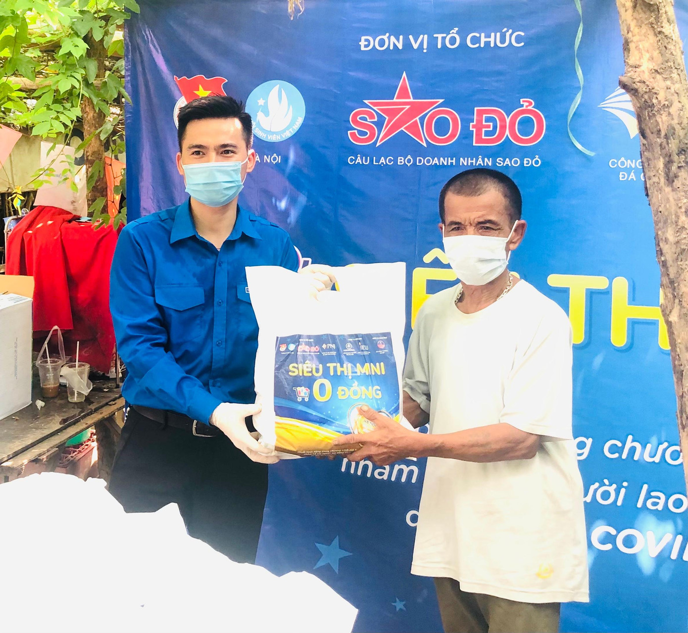 Ông Nguyễn Đăng Được, xóm trưởng nhận nhu yếu phẩm từ anh Lý Duy Xuân, Phó Bí thư Thành Đoàn Hà Nội.