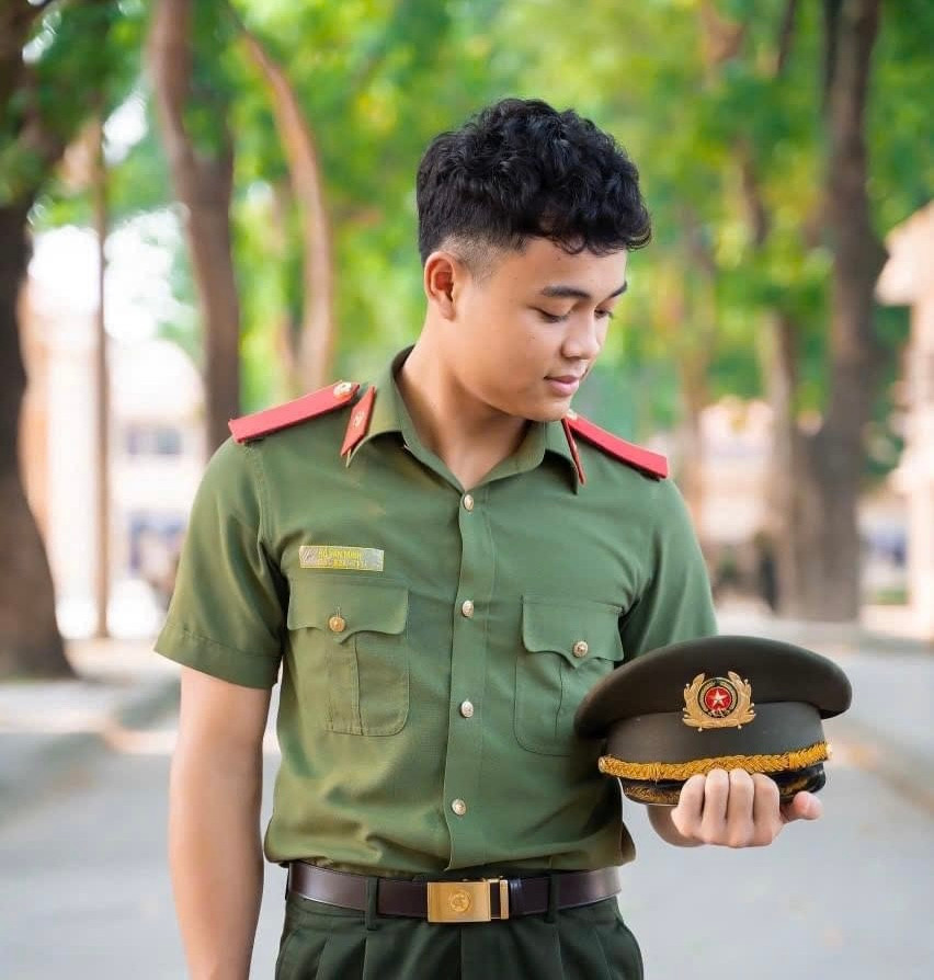 Em Minh trong bộ quân phục Công an. Em Minh trong bộ quân phục Công an.