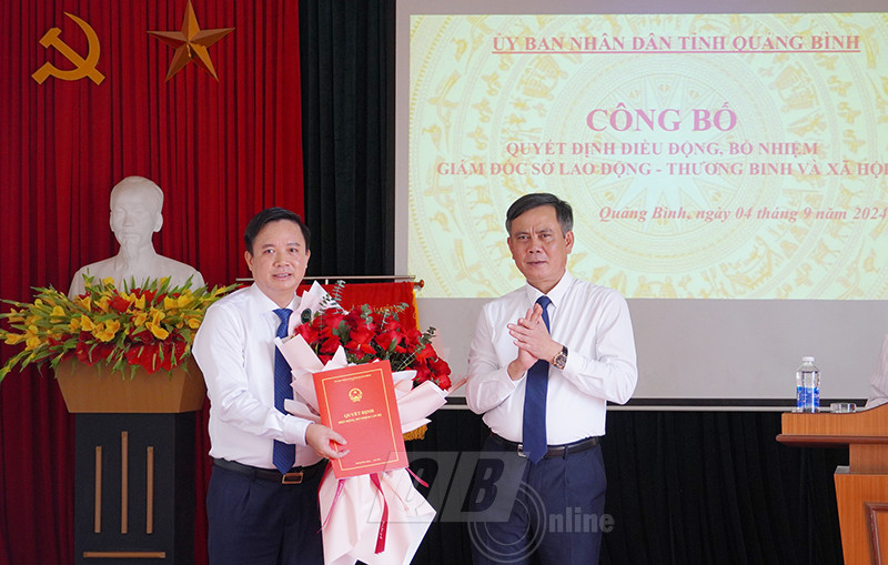 Ông Trần Thắng trao quyết định và tặng hoa chúc mừng ông Phạm Tiến Nam.