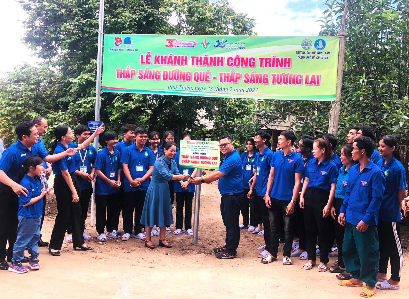 Các thanh niên tình nguyện dọn dẹp đường quê, tặng quà cho các em nhỏ ở buôn làng