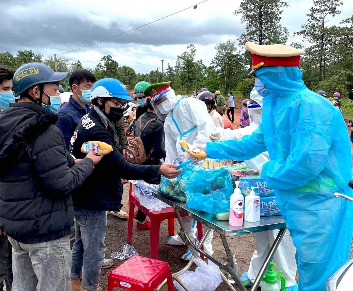 Các chiến sĩ Công an huyện Đức Cơ đợi người dân đến để tiếp nước, bánh mì, xăng