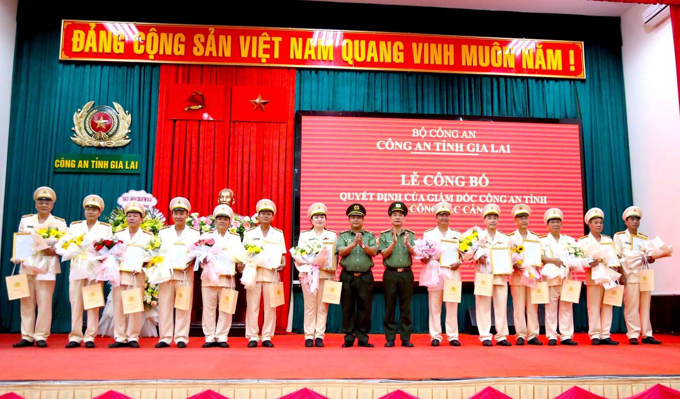 Thiếu tướng Rah Lan Lâm (thứ 8, trái qua) và đại tá Phạm Hữu Phường - Phó Giám đốc Công an tỉnh Gia Lai trao quyết định, tặng hoa cho các cán bộ công an nghỉ công tác, nghỉ hưu