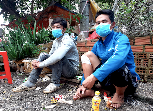 Anh Đinh Xuân Hiền (áo xanh) và người em họ đợi kiểm dịch ở Chốt 110