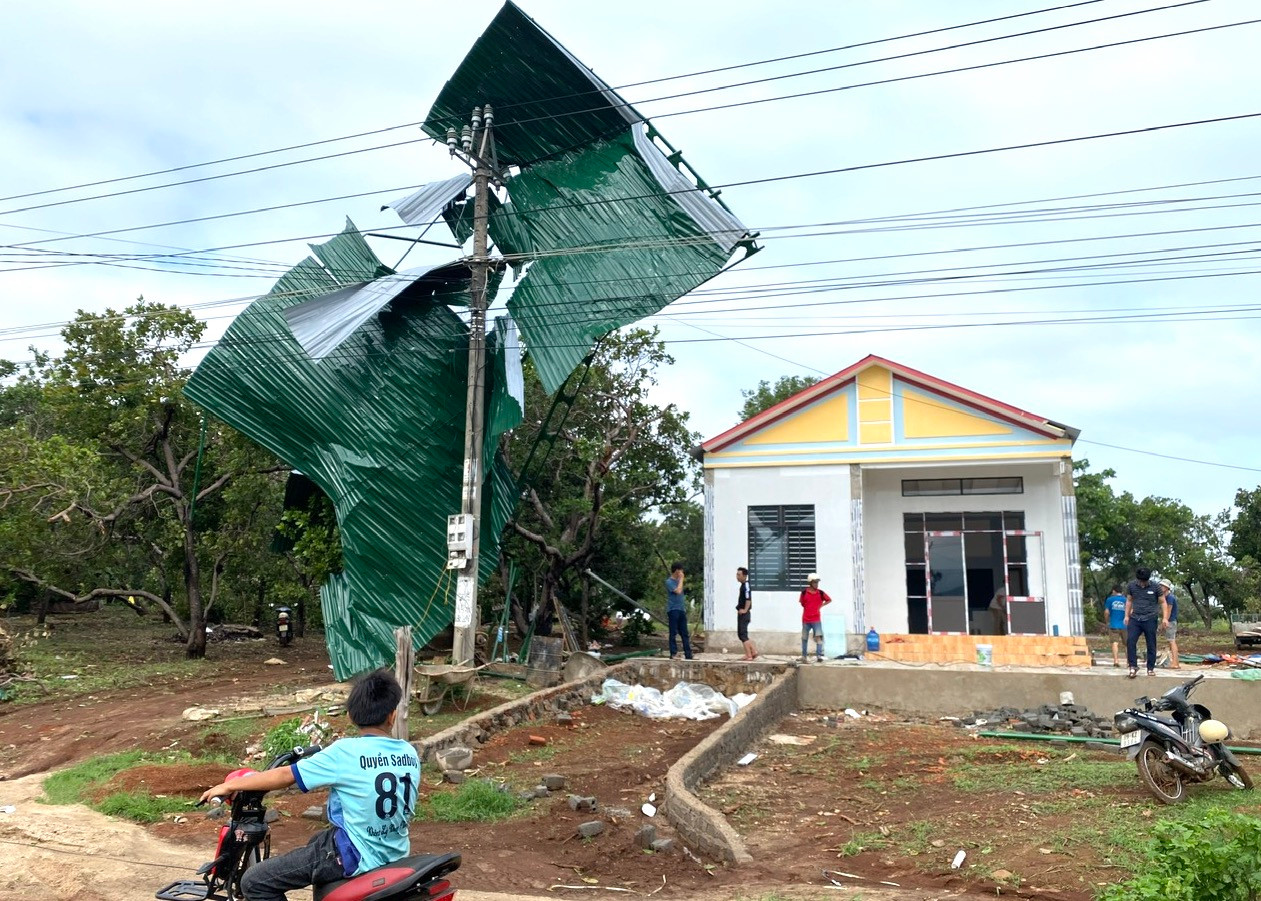 Mái tôn bị gió thổi bay lên cột điện.