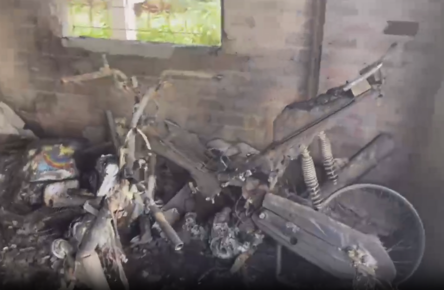 Chiếc xe máy trong căn phòng trọ đã bị lửa làm cho hư hỏng hoàn toàn.