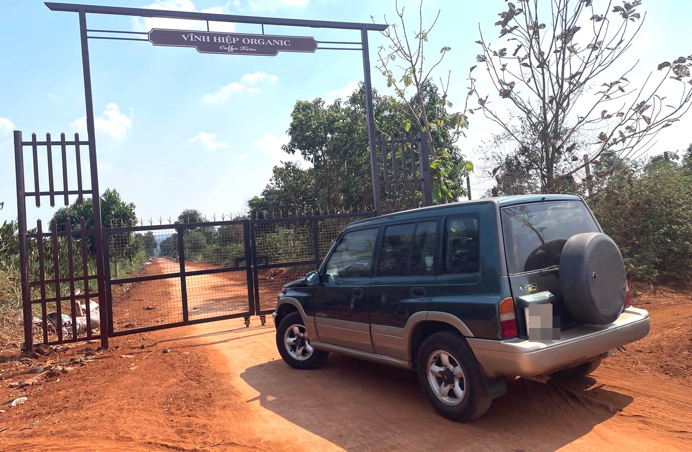 Trên cổng sắt có ghi "Vĩnh Hiệp Organic - Coffee Fram"