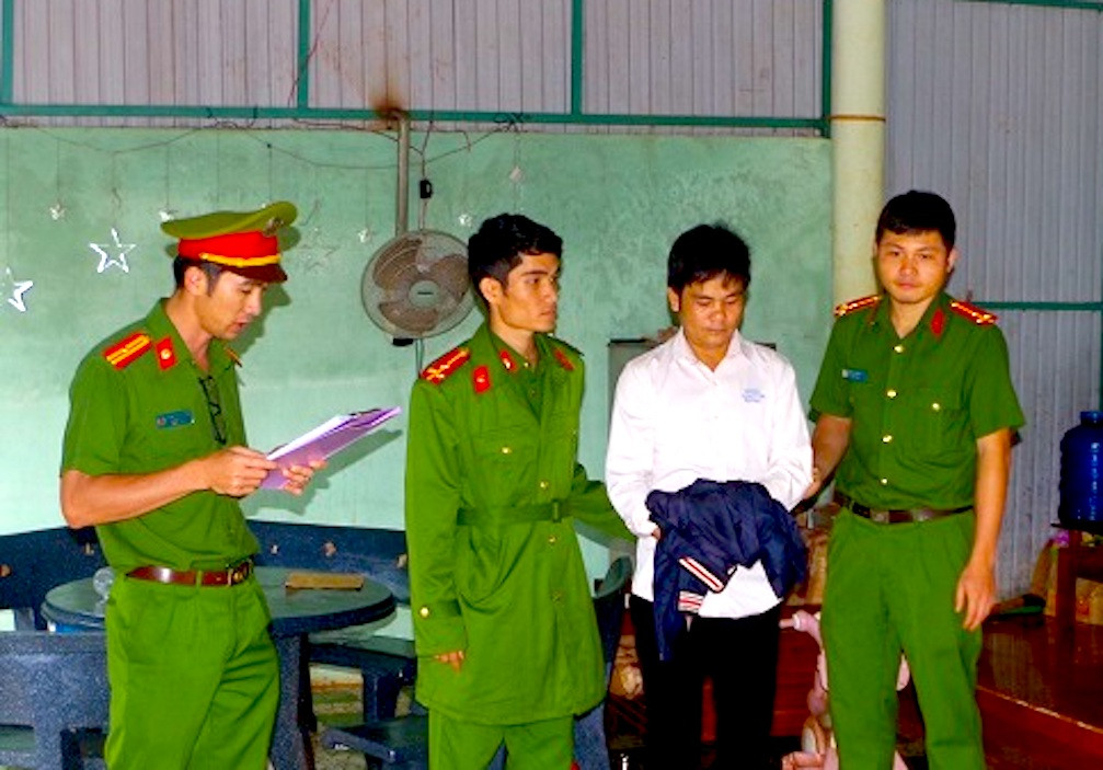 Công an thi hành lệnh bắt bị can để tạm giam đối với Hoàng Quốc Thắng (áo trắng). Ảnh: Đỗ Linh