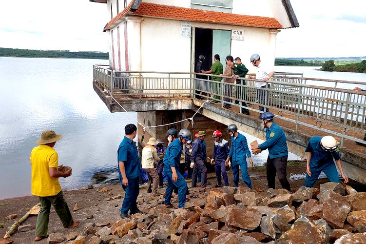 Người dân cùng chính quyền địa phương lấy đá lấp lại lỗ thủng