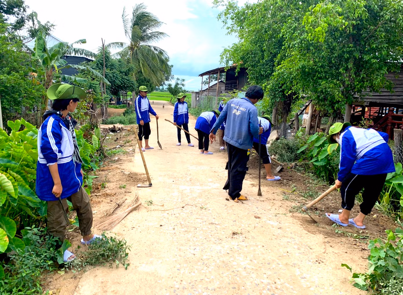 Các thanh niên tình nguyện dọn dẹp đường quê, tặng quà cho các em nhỏ ở buôn làng