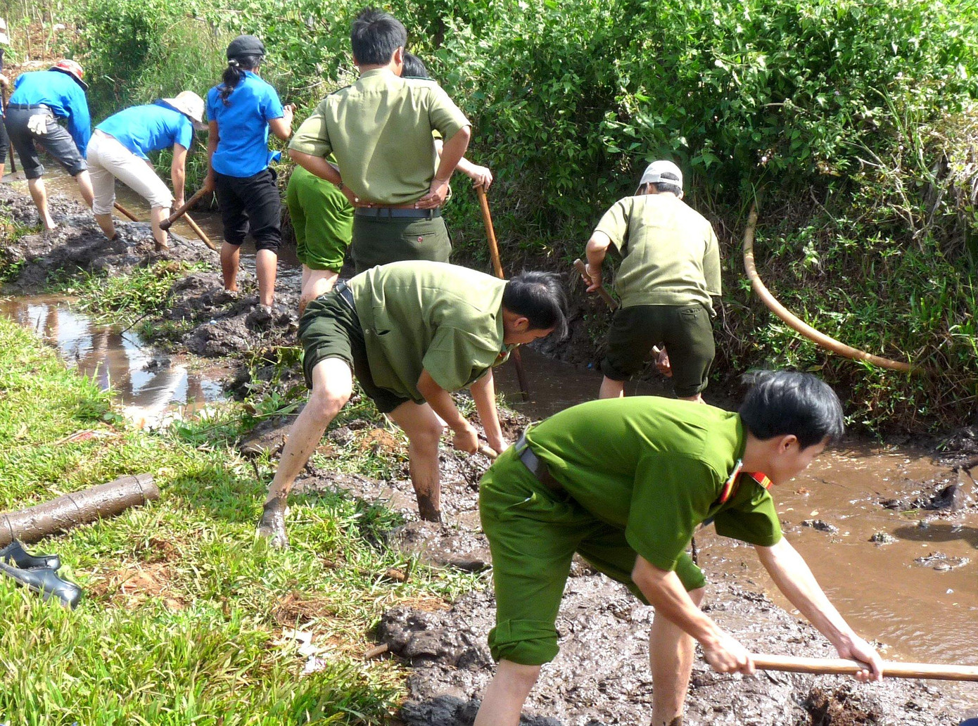 Lực lượng công an cùng người dân sửa chữa kênh mương