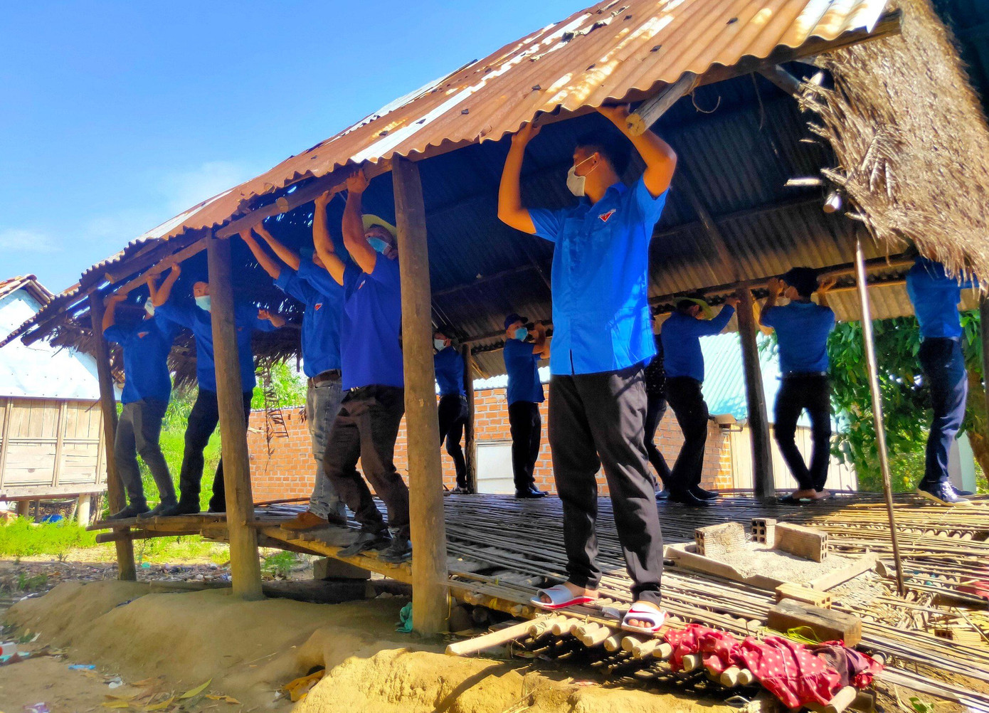 Các chiến sỹ công an, thanh niên địa phương sửa chữa nhà giúp dân