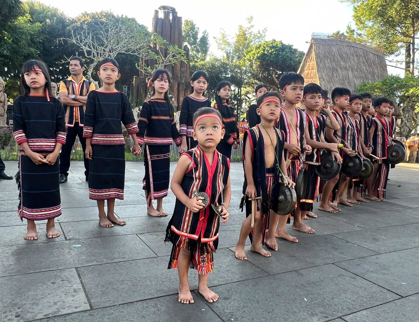 Các em nhỏ người dân tộc thiểu số gõ chiêng cổ vũ các "nhà leo núi"