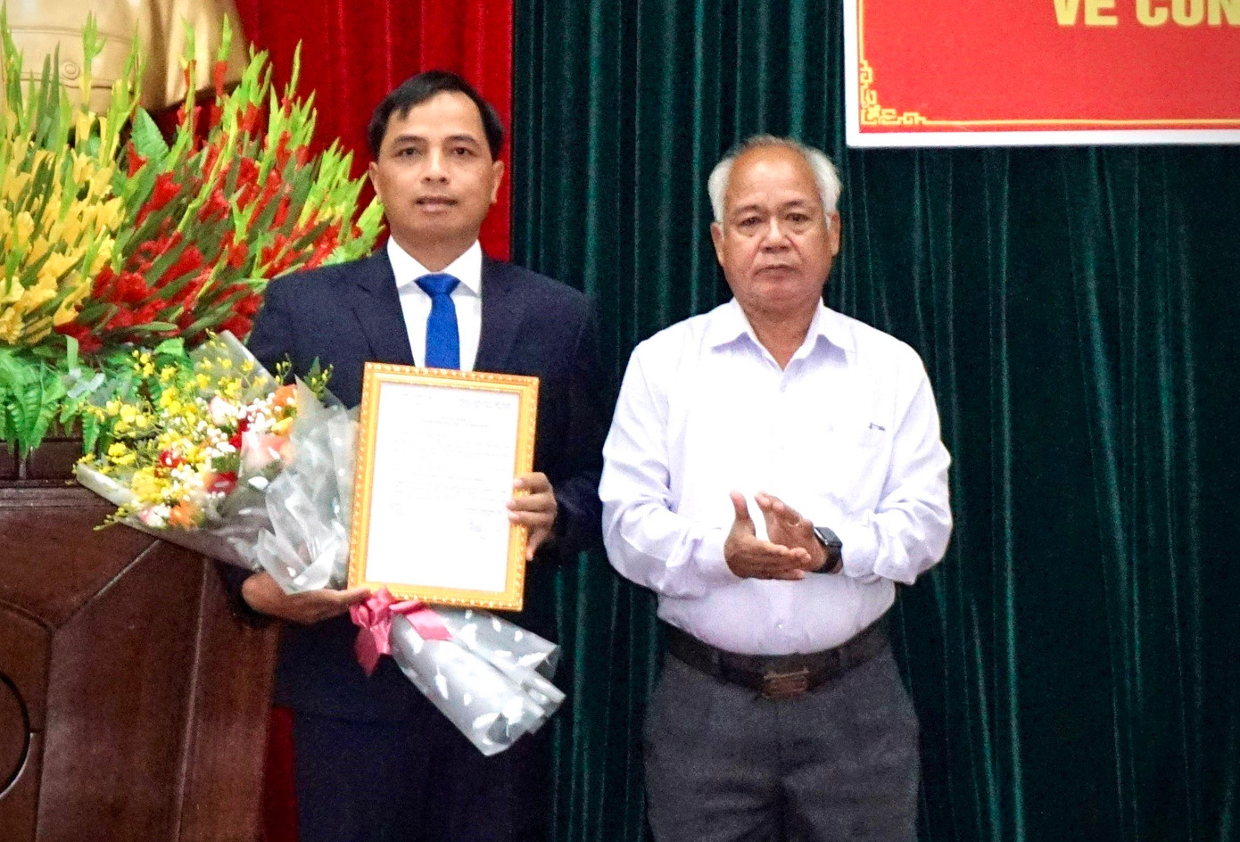 Phó Bí thư Thường trực Tỉnh ủy A Pớt trao quyết định và tặng hoa cho ông Xiêng Thanh Phúc.