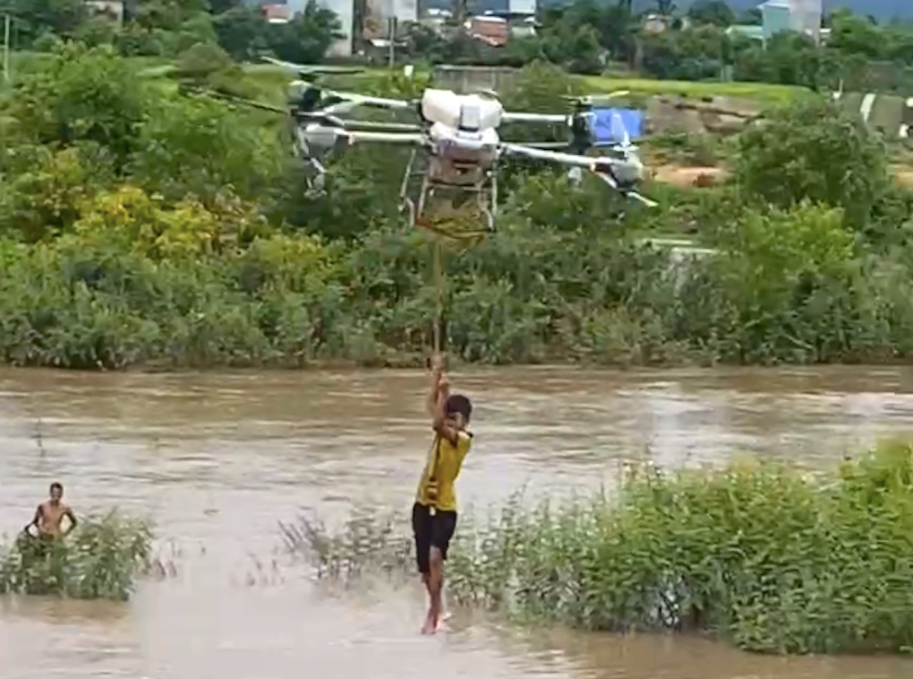 Các em nhỏ bám vào sợi dây, máy bay không người lái đưa vào bờ.