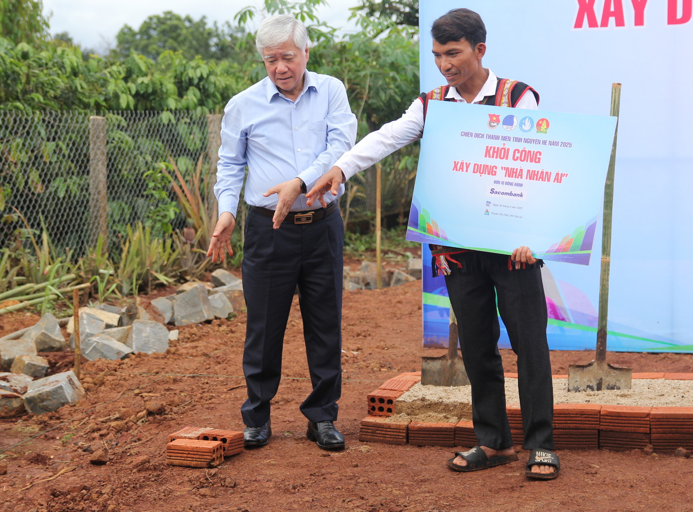 Chủ tịch Ủy ban T.Ư Mặt trận Tổ quốc Việt Nam Đỗ Văn Chiến hướng dẫn bố của em Quyên cách làm một căn nhà vững chắc, thoáng mát.