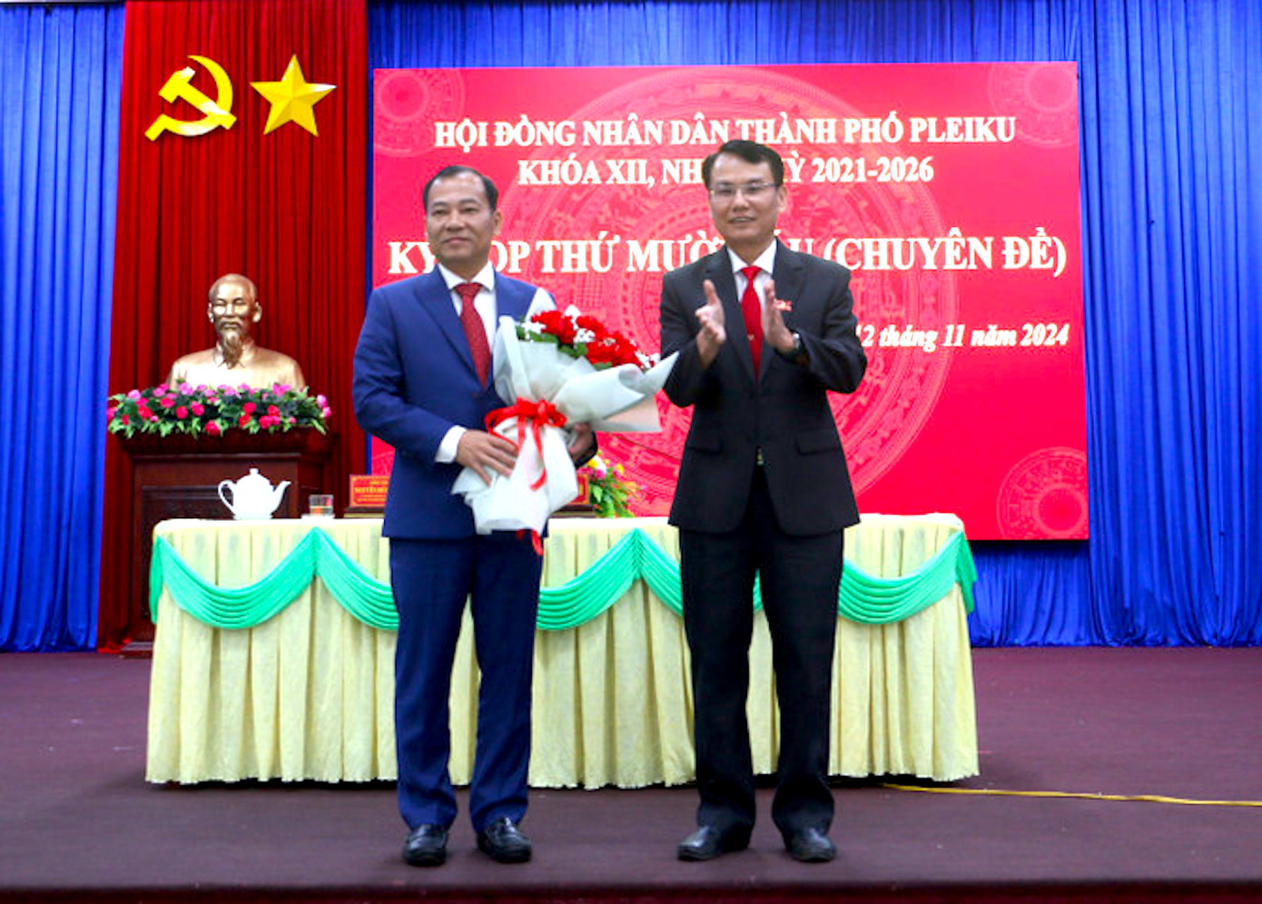 Ông Trịnh Duy Thuân - Bí thư Thành ủy, Chủ tịch HĐND TP. Pleiku, tặng hoa chúc mừng tân Chủ tịch UBND TP. Pleiku