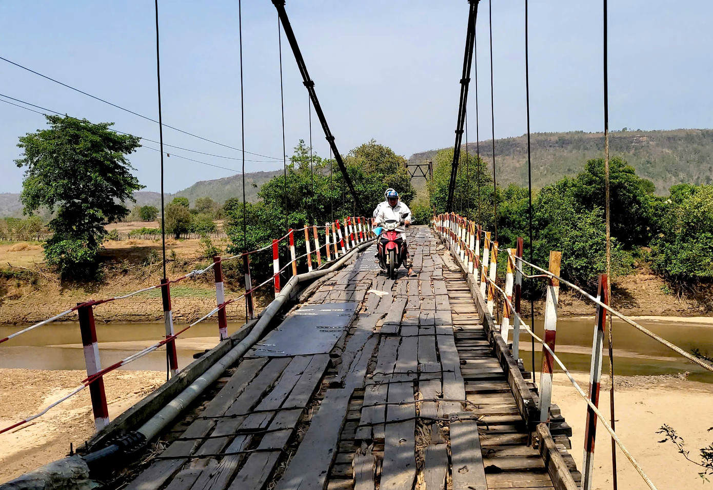 Mặt cầu treo làng Tung Ke được lót tạm bằng ván gỗ. Mặt cầu treo làng Tung Ke được lót tạm bằng ván gỗ.