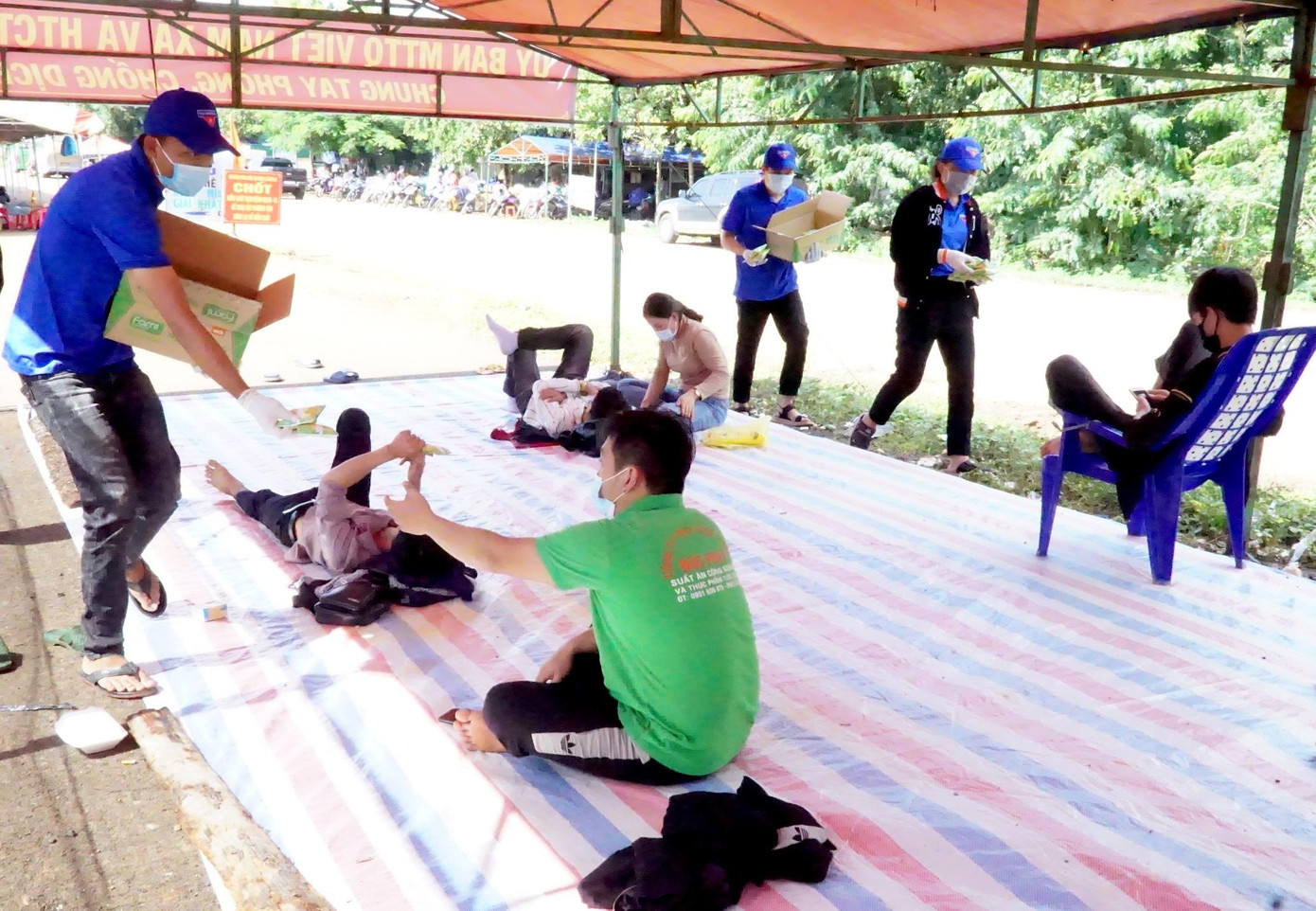 Thanh niên tình nguyện phát sữa cho mọi người vừa đi xa tới