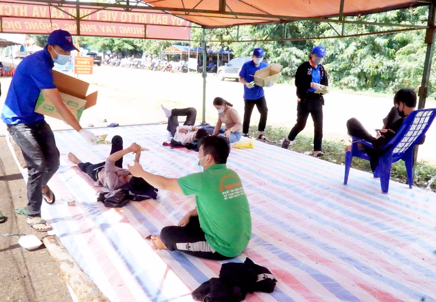 Thanh niên tình nguyện phát sữa cho mọi người vừa đi xa tới