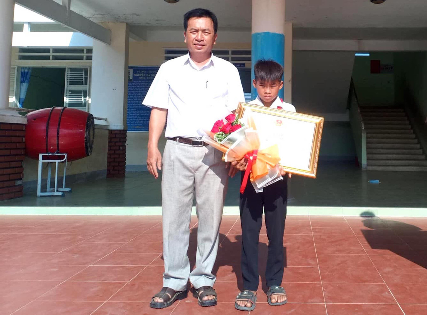 Ông Ksor Suy tặng bằng khen cho em Kpă Nguyên