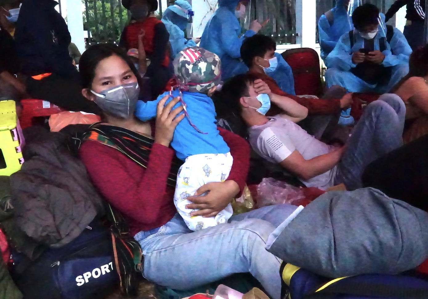 Chị Ra Lan Chíu (20 tuổi, xã Chư Pơng, huyện Chư Sê, Gia Lai) ôm con nhỏ mới 8 tháng tuổi cùng chồng đi xe máy từ Đồng Nai về hơn 400km