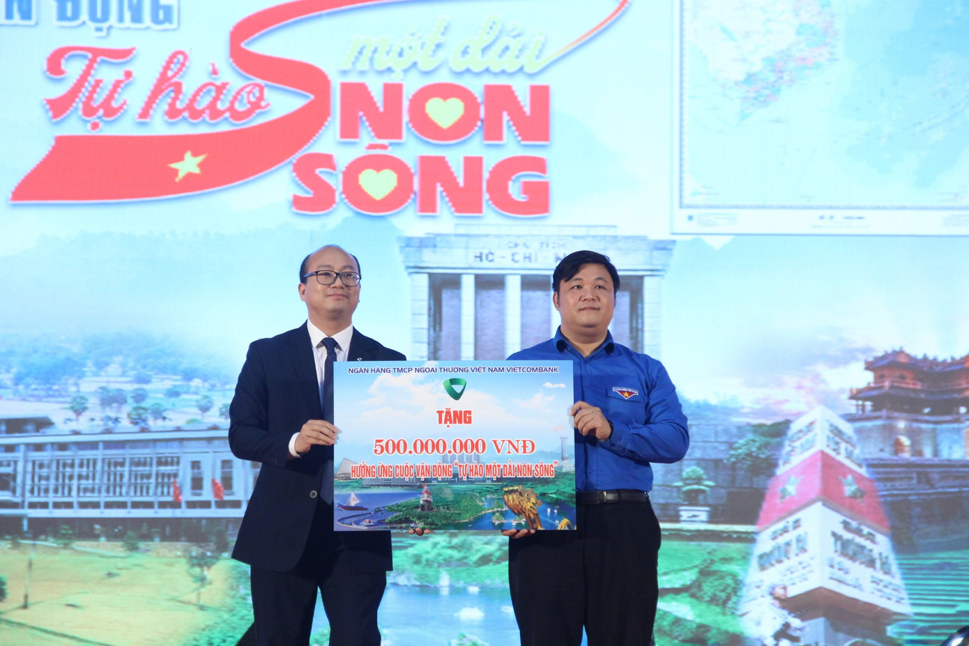 Đồng chí Dương Bảo Trung - Đại diện Vietcombank (bên trái) trao biển tượng trưng tặng kinh phí tài trợ mua bản đồ cho các địa phương khó khăn.