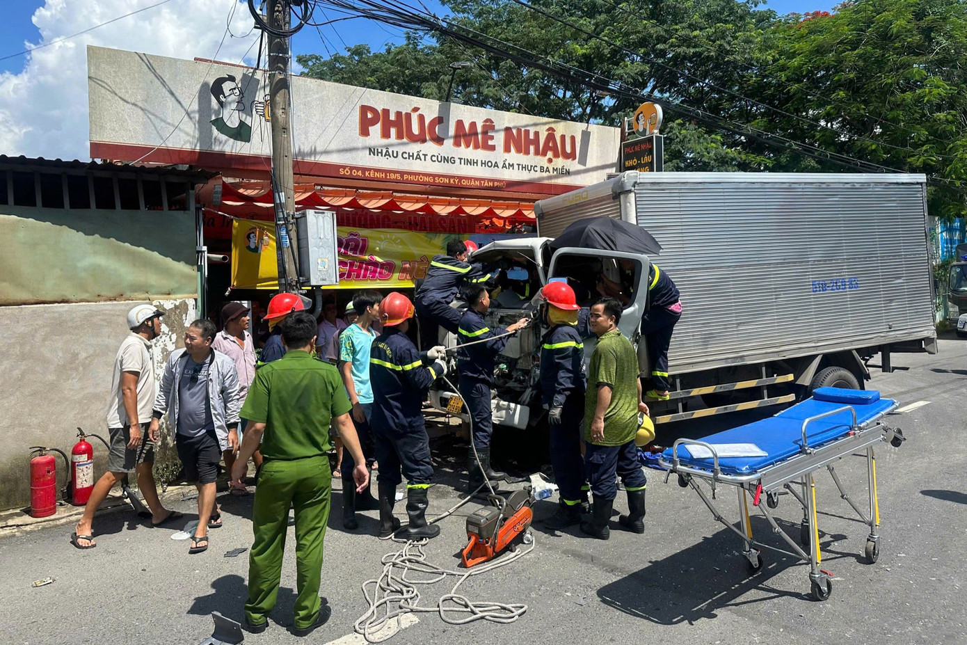 Lực lượng chức năng phá cabin đưa tài xế ra ngoài. Ảnh: C.A.