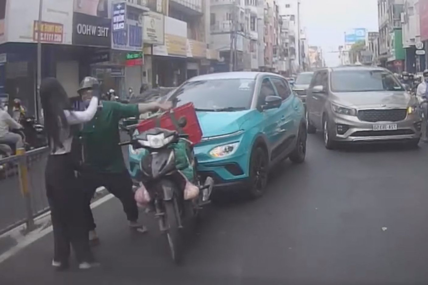 Nữ tài xế công nghệ ẩu đả với nam thanh niên giao hàng trên đường phố đông người. Ảnh cắt từ clip. Nữ tài xế công nghệ ẩu đả với nam thanh niên giao hàng trên đường phố đông người. Ảnh cắt từ clip.