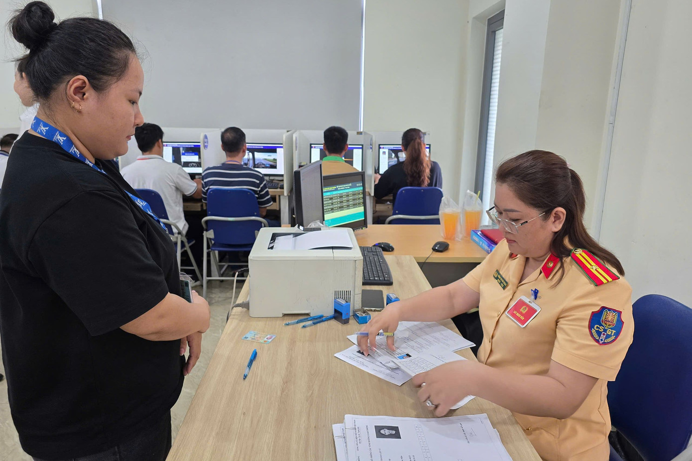 CSGT hướng dẫn người dân thực hiện thủ tục thi. Ảnh: H.T.