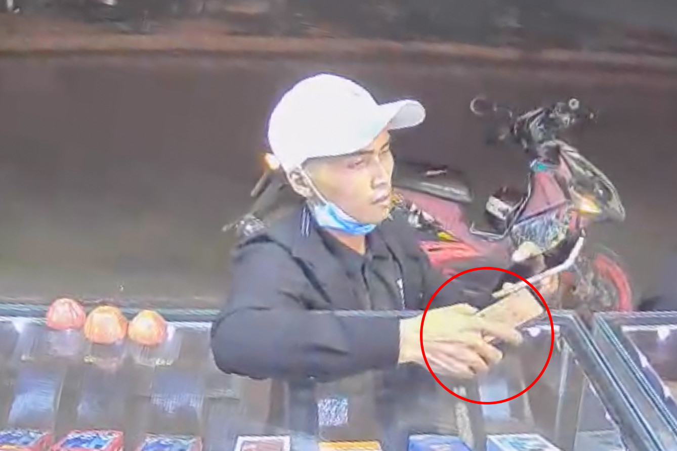 Nam thanh niên lấy điện thoại của anh Đ. Ảnh cắt từ clip.