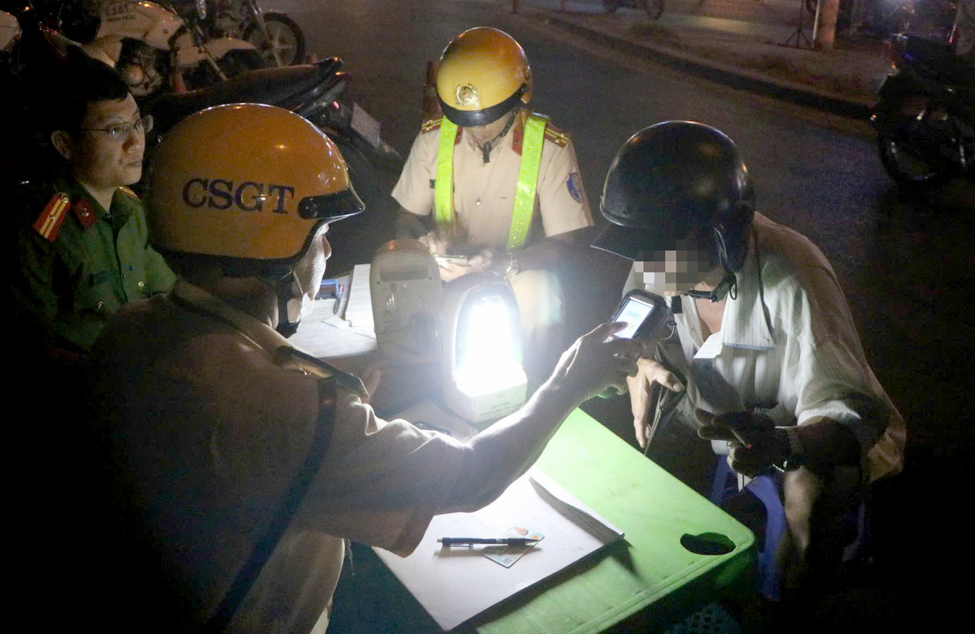 Lực lượng CSGT kiểm tra nồng độ cồn đối với người đi xe máy. Ảnh: C.A. Lực lượng CSGT kiểm tra nồng độ cồn đối với người đi xe máy. Ảnh: C.A.