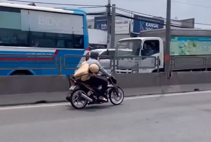 Hình ảnh cán bộ CSGT bám sau yên xe máy của nam thanh niên. Ảnh cắt từ clip.