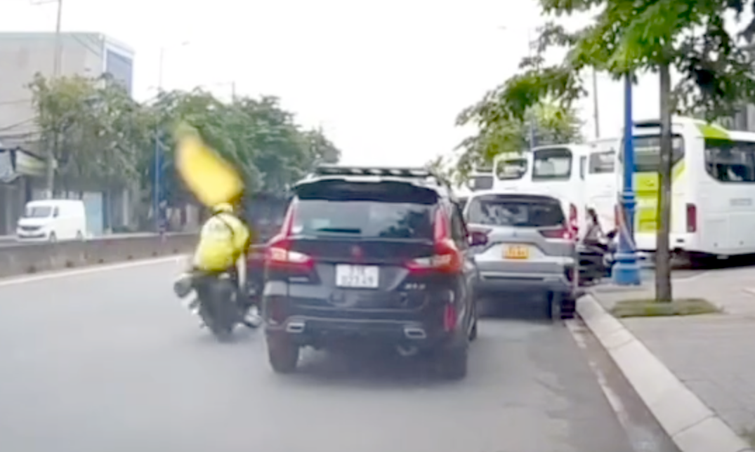 Tài xế ô tô mở cửa không quan sát khiến tài xế xe ôm công nghệ ngã nhào xuống đường. Ảnh cắt từ clip. Tài xế ô tô mở cửa không quan sát khiến tài xế xe ôm công nghệ ngã nhào xuống đường. Ảnh cắt từ clip.