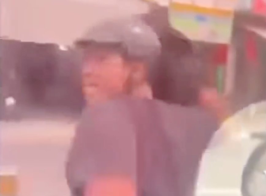 Người đàn ông quấn áo khoác vào tay rồi đập kính ô tô. Ảnh cắt từ clip Người đàn ông quấn áo khoác vào tay rồi đập kính ô tô. Ảnh cắt từ clip