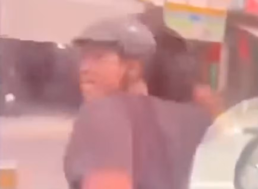 Người đàn ông quấn áo khoác vào tay rồi đập kính ô tô. Ảnh cắt từ clip