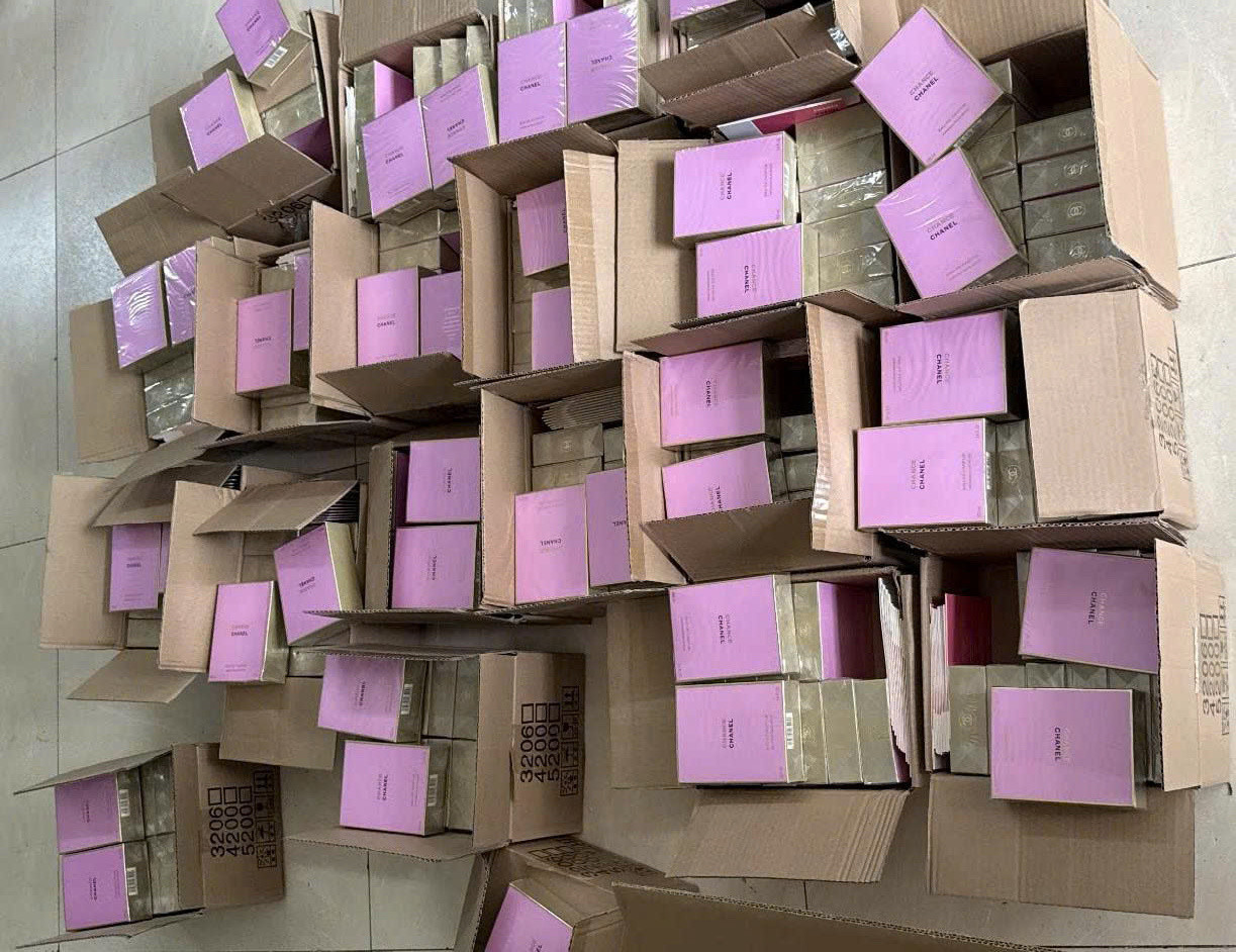 Các đối tượng làm giả các loại nước hoa giả nổi tiếng. Ảnh: Công an cung cấp.