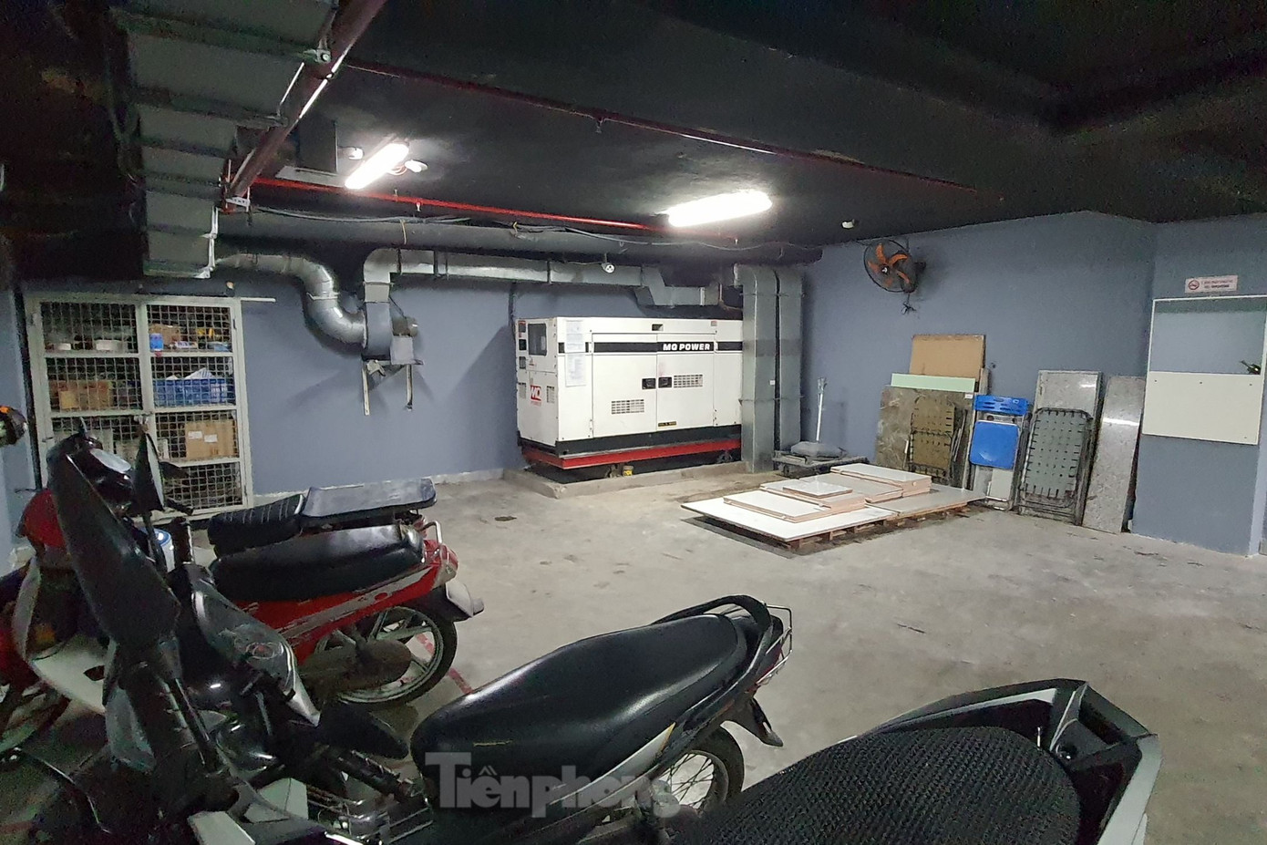 Đoàn kiểm tra yêu cầu cơ sở xây dựng tường ngăn cách máy phát điện với xe máy ở khu vực tầng hầm. Ảnh: Hoàng Thuận.