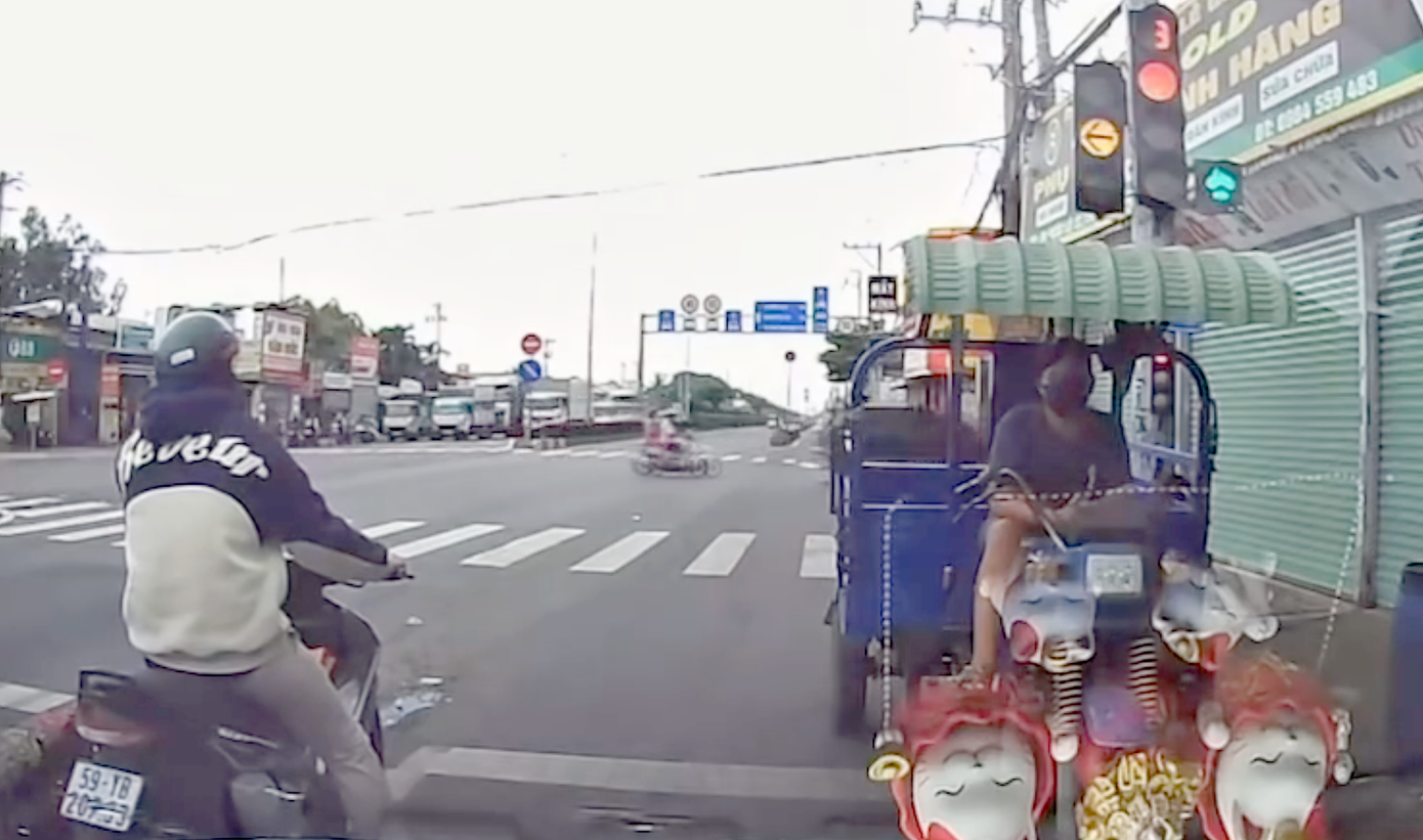 Nam thanh niên chạy xe ba gác đi ngược chiều, chặn đầu ô tô. Ảnh cắt từ clip.