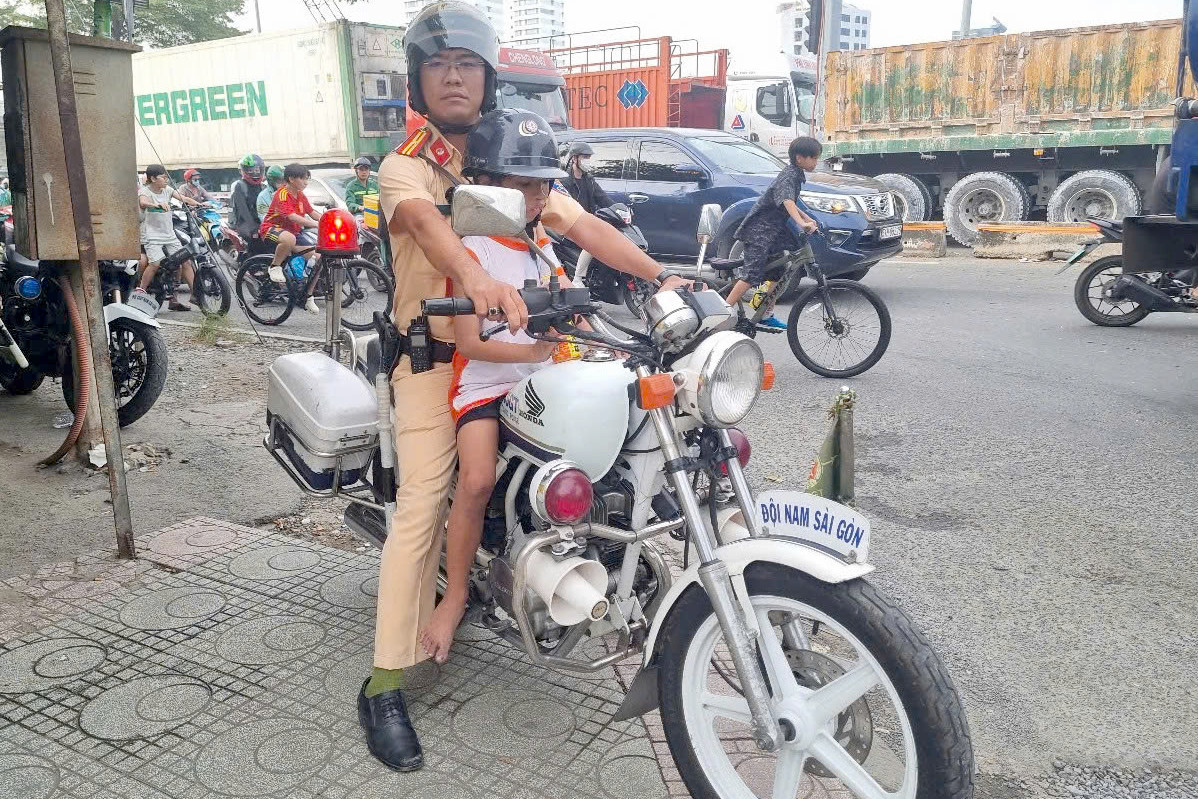 Thiếu tá Phan Minh Châu dùng xe đặc chủng chở cháu bé đi lạc về trụ sở Công an phường Tân Phong để phối hợp tìm thông tin gia đình. Ảnh: PC08. Thiếu tá Phan Minh Châu dùng xe đặc chủng chở cháu bé đi lạc về trụ sở Công an phường Tân Phong để phối hợp tìm thông tin gia đình. Ảnh: PC08.