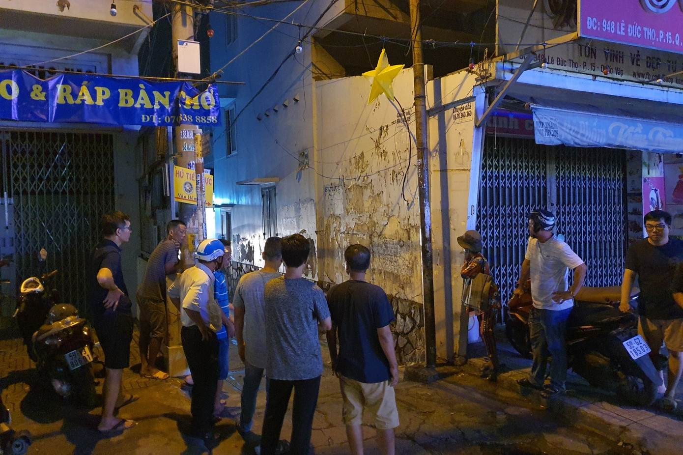 Người dân tập trung trước con hẻm dẫn vào ngôi nhà xảy ra cháy. Ảnh: H.T.