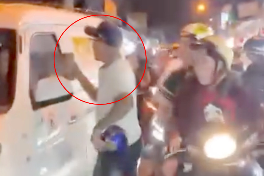 Người đàn ông cầm gạch đá đe dọa tài xế. Ảnh cắt từ clip. Người đàn ông cầm gạch đá đe dọa tài xế. Ảnh cắt từ clip.