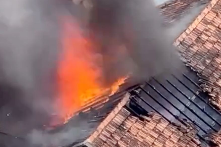 Lửa đỏ rực trên nóc căn hộ. Ảnh cắt từ clip. Lửa đỏ rực trên nóc căn hộ. Ảnh cắt từ clip.