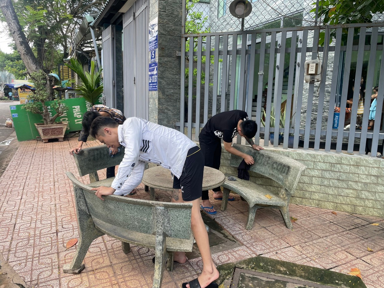 Công an đưa các đối tượng đi tẩy, xóa các thông tin quảng cáo trái phép (Ảnh: Công an cung cấp).