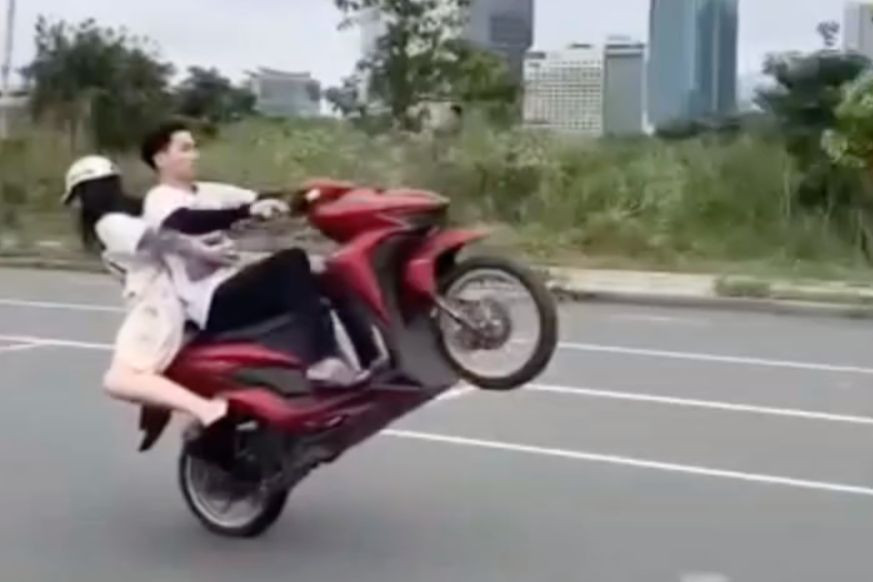 Hình ảnh nam thanh niên không đội mũ bảo hiểm, bốc đầu xe máy gây xôn xao dư luận. Ảnh cắt từ clip.