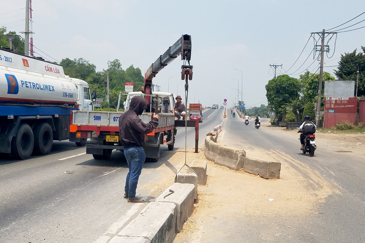 Nhân viên của đơn vị quản lý tuyến đường lắp đặt lại dải phân cách bị húc văng (Ảnh: M.A.).