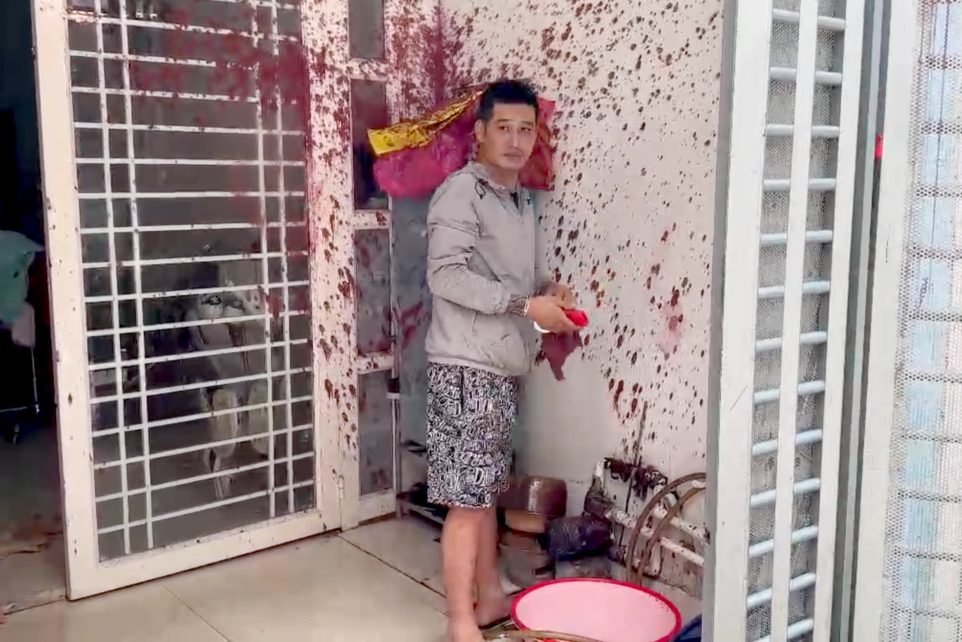 Công an đưa Lực đến nhà bà S để lau chùi, tẩy xóa vết sơn. Ảnh: Công an cung cấp.