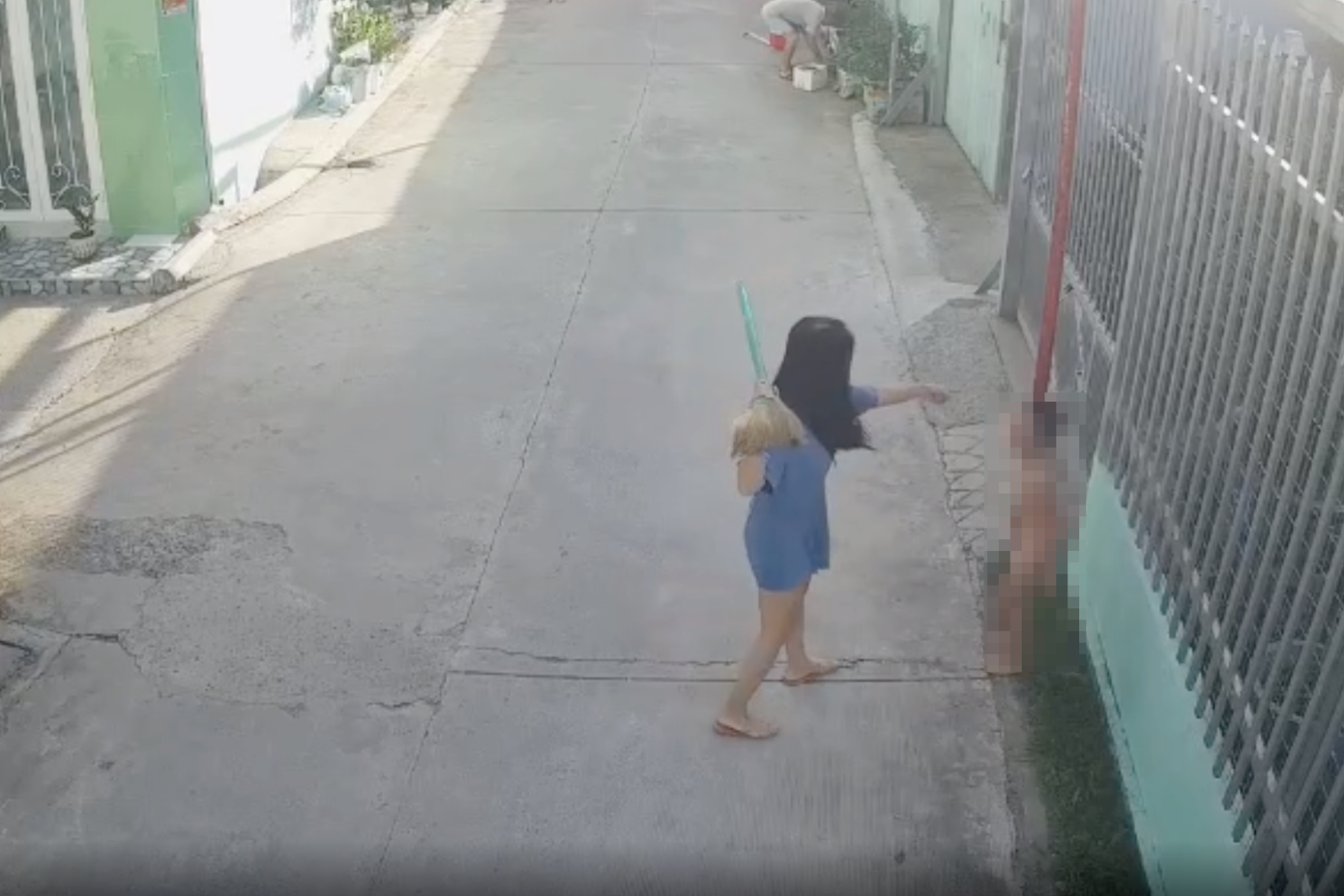 Camera ghi lại cảnh bà Trang dùng chổi đánh cháu T. Ảnh cắt từ clip.