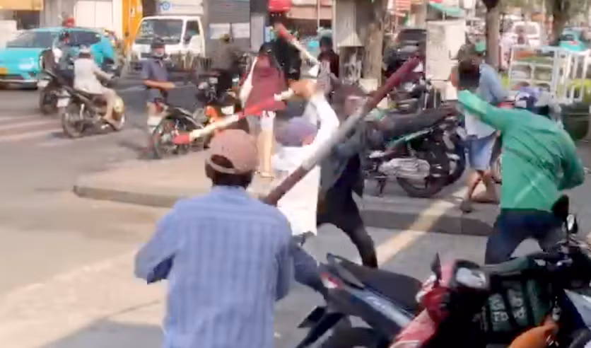 Nhóm tài xế xe ôm truyền thống dùng gậy tre đánh tài xế xe ôm công nghệ. Ảnh cắt từ clip.