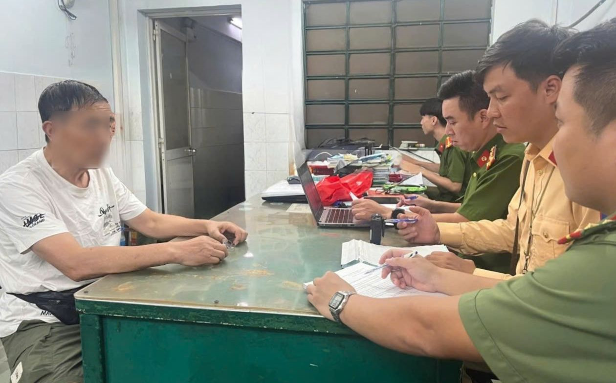 Lực lượng chức năng làm việc với người đàn ông điều khiển vali điện trên đường. Ảnh: PC08.